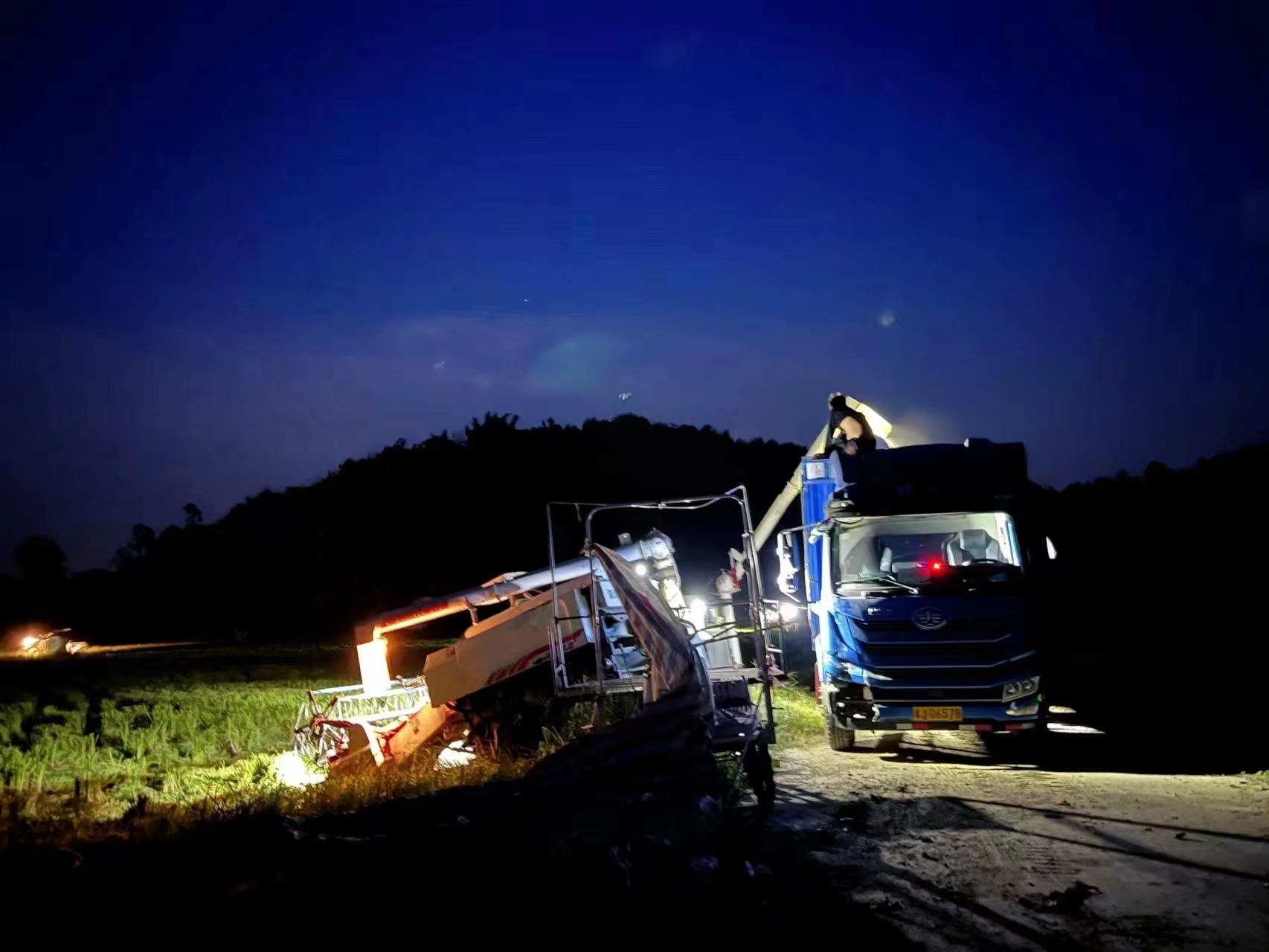 15日深夜，在恩平市牛江鎮(zhèn)黃泥坦村田邊，村民將剛剛搶收下來的水稻裝車送往烘干中心。江門市恩平市委宣傳部供圖